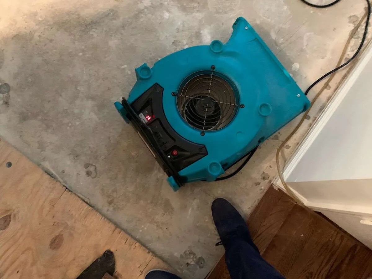 Air mover drying subfloor during Commercial Water Damage Restoration in Gray